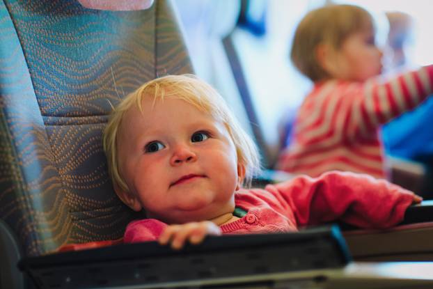 cute little baby girl travel by plane