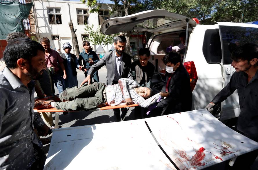 Men move an injured man to a hospital after a blast in Kabul, Afghanistan