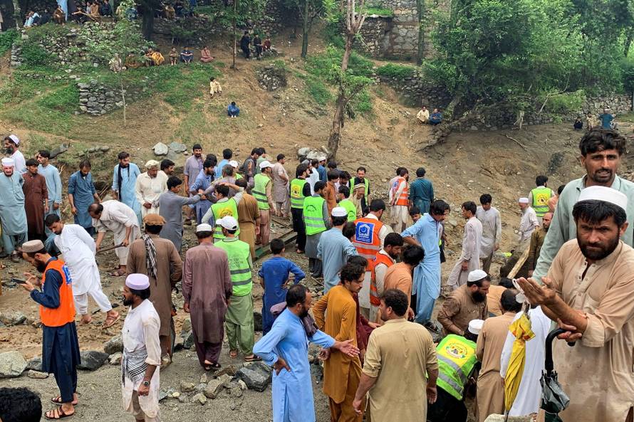 Rescue workers and residents gather after cloudburst following heavy rains and flooding, in Jibrari village in Salarzai Tehsil