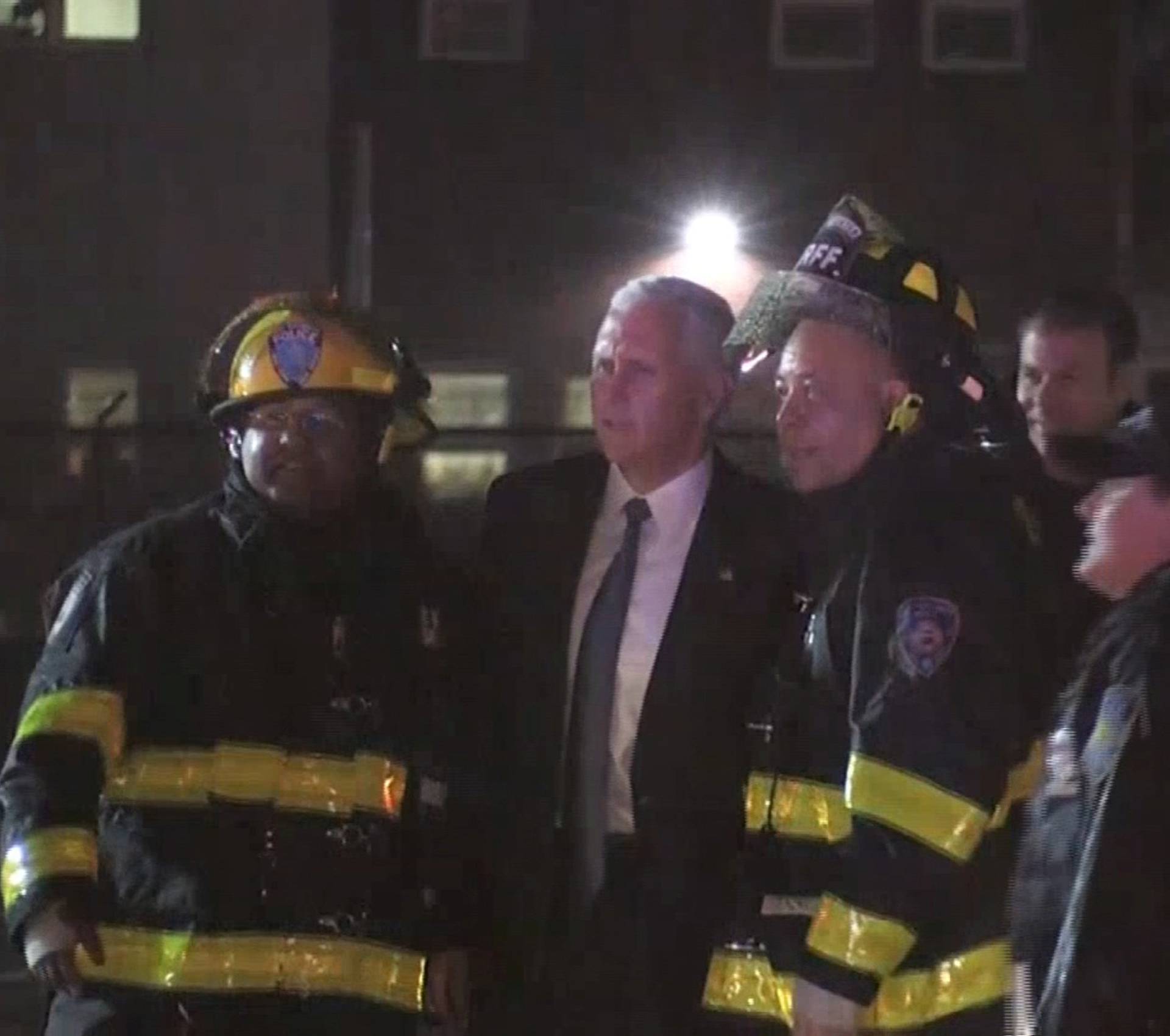 Still image of U.S. Republican vice presidential nominee Pence posing for a photo with firefighters after a plane carrying him skidded off the runway after landing in the rain at New York City's LaGuardia Airport