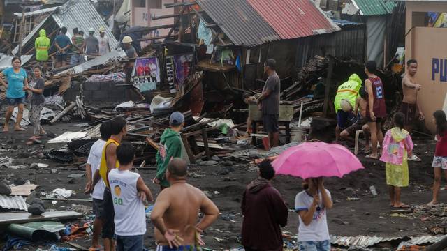 Residents stand among their damaged houses after Typhoon Kammuri hit Legazpi City, Albay
