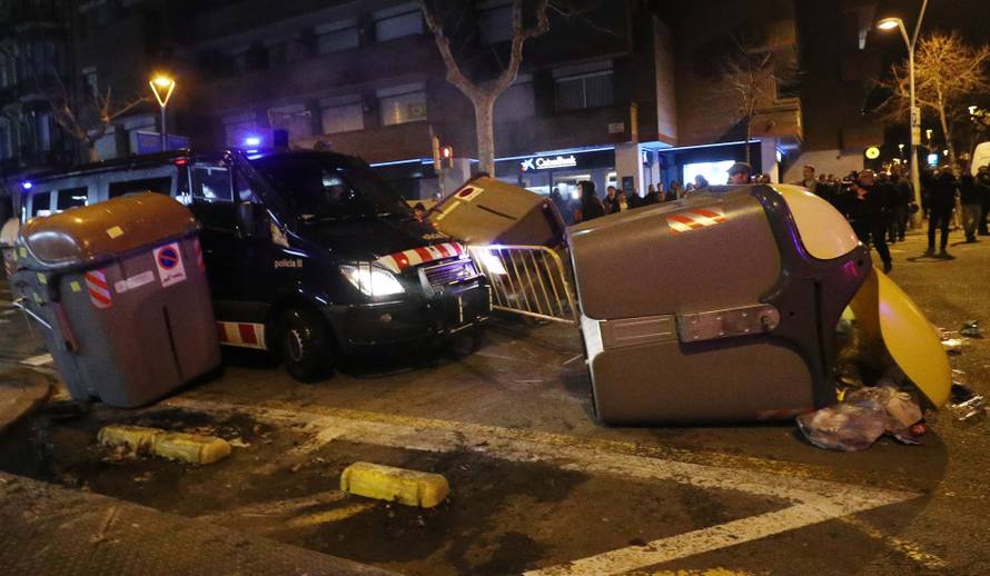 A Catalan police van drives through barricades placed by protestors during skirmishes after former regional president Carles Puigdemont was detained in Germany,  in Barcelona