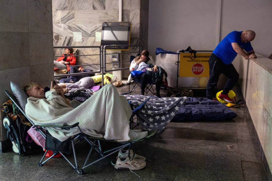 People take shelter in a metro station during a Russian drone attack in Kyiv