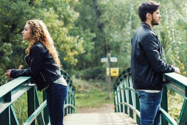 Young couple being in a conflict in the park. 