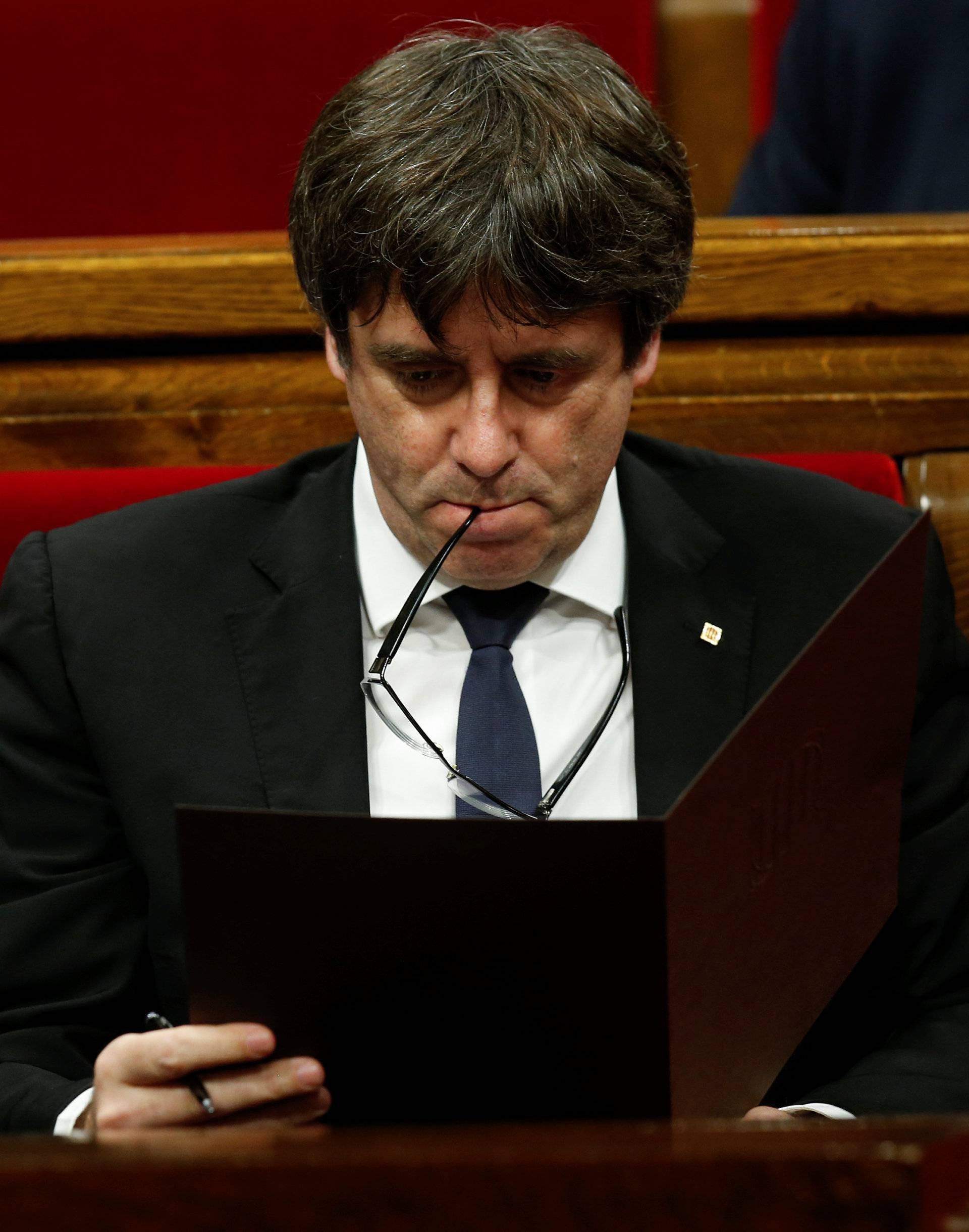 Catalan President Carles Puigdemont reviews his notes at the start of a plenary session at the Catalonian regional parliament in Barcelona