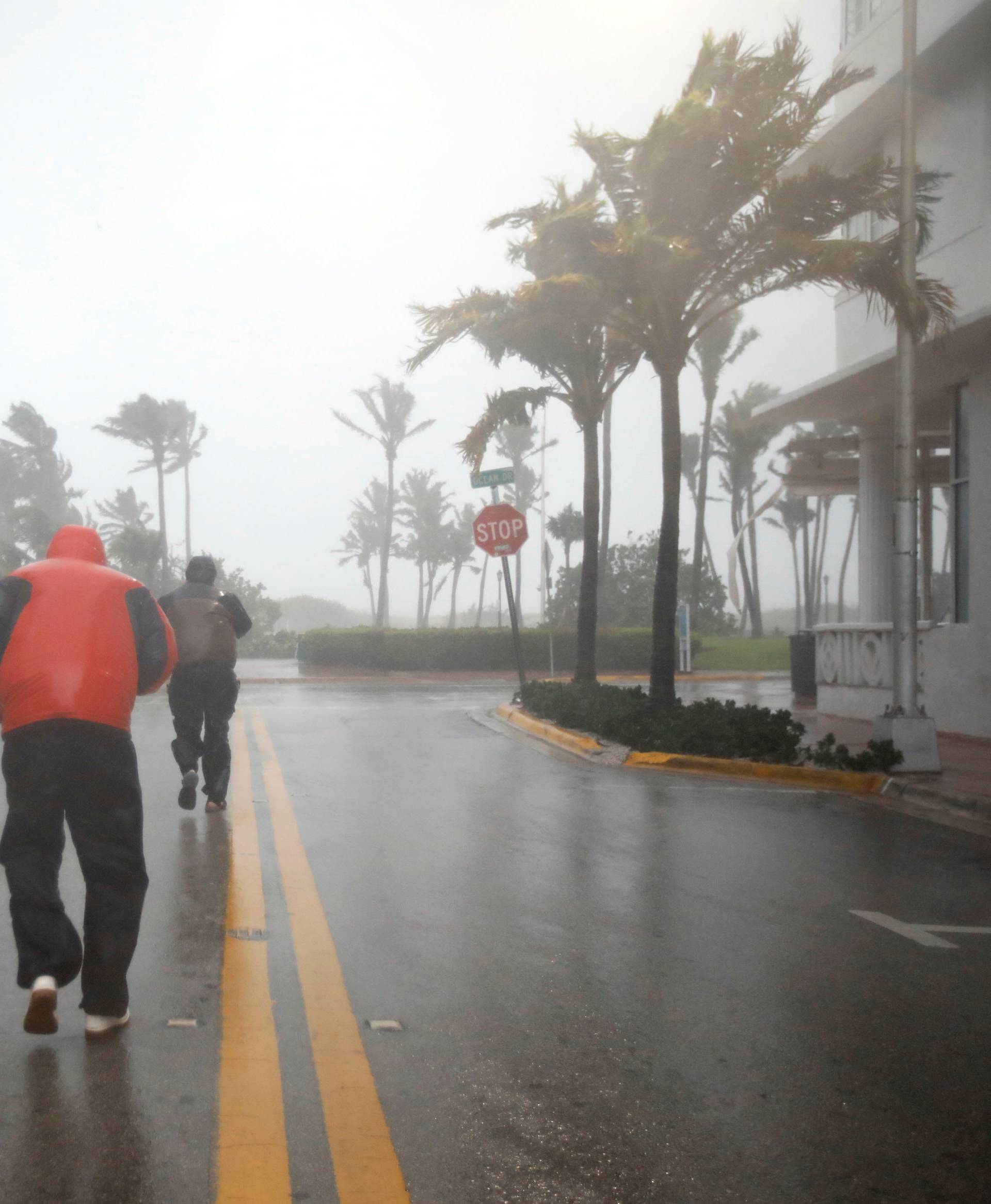 People walk along a street in South Beach as Hurricane Irma arrives at south Florida, in Miami Beach