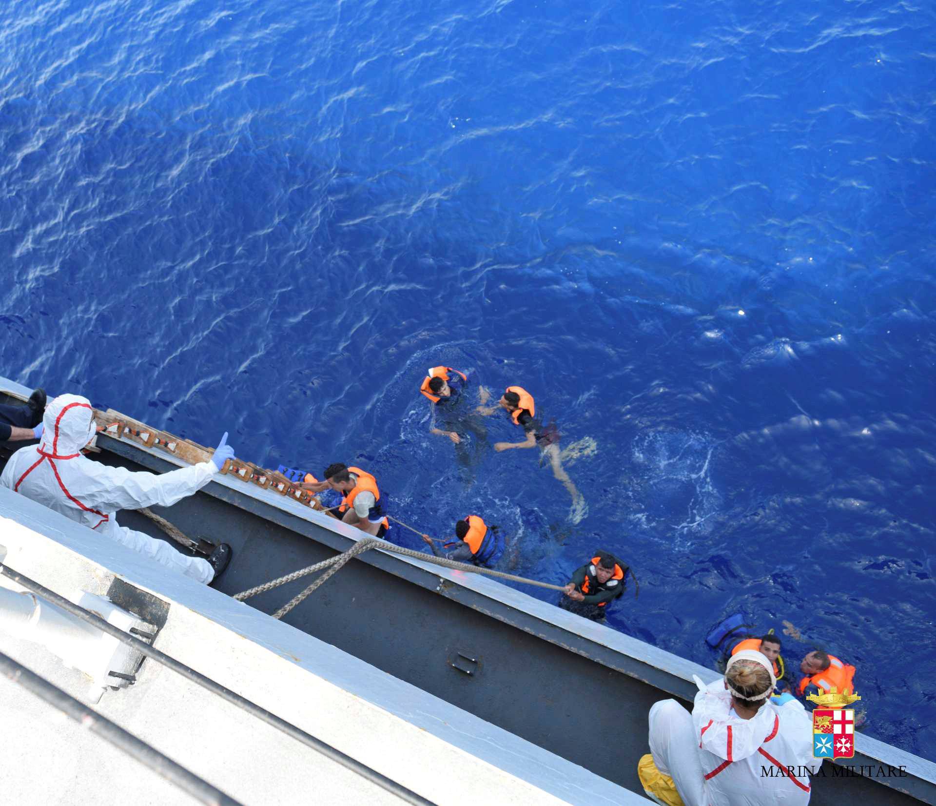 Migrants from a capsized boat are rescued during a rescue operation by Italian navy ships "Bettica" and "Bergamini" off the coast of Libya