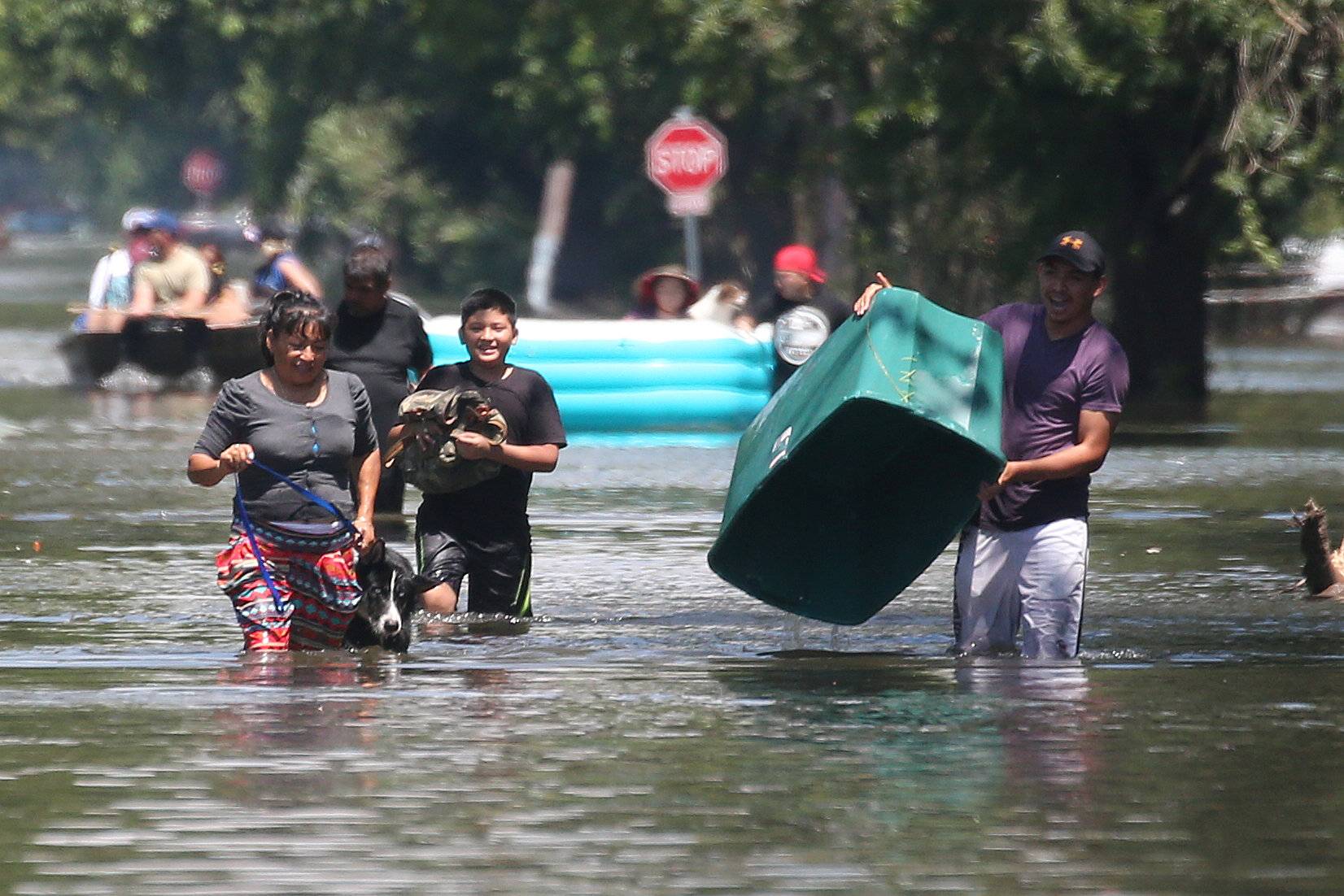 People walk with their possessions out of a flooded area of Port Arthur, Texas