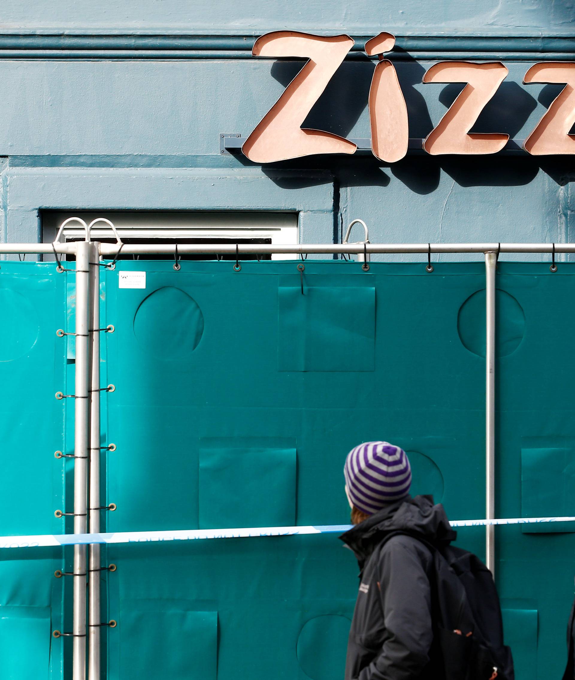 People walk past a restaurant which has been secured as part of the investigation into the poisoning of former Russian inteligence agent Sergei Skripal and his daughter Yulia, in Salisbury