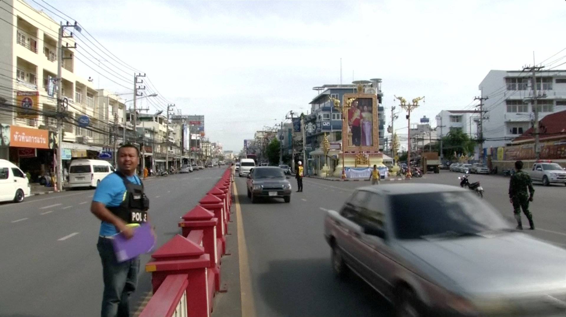 A police officer stands along Hua Hin's main road near the Hua Hin Clock Tower, near the site of a bomb blast in Hua Hin