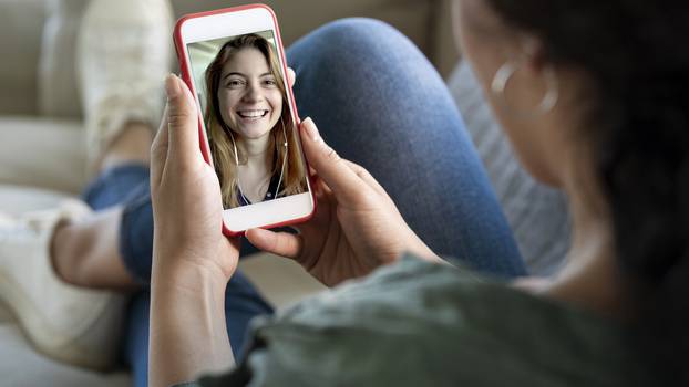 Young woman using smartphone for video call