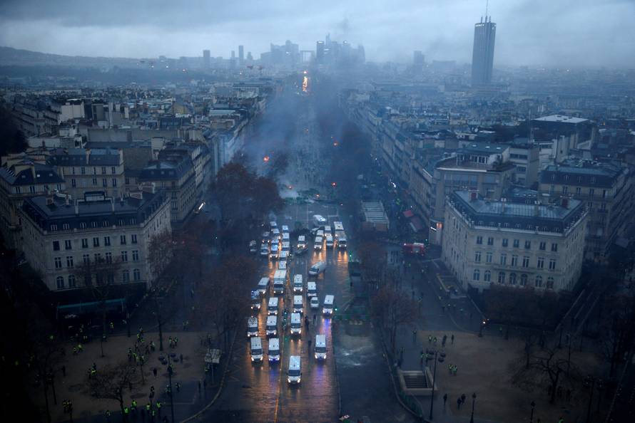 A general view shows police forces and protesters wearing yellow vests, a symbol of a French drivers' protest against higher diesel taxes, during clashes as part of a demonstration near the Place de l'Etoile in Paris