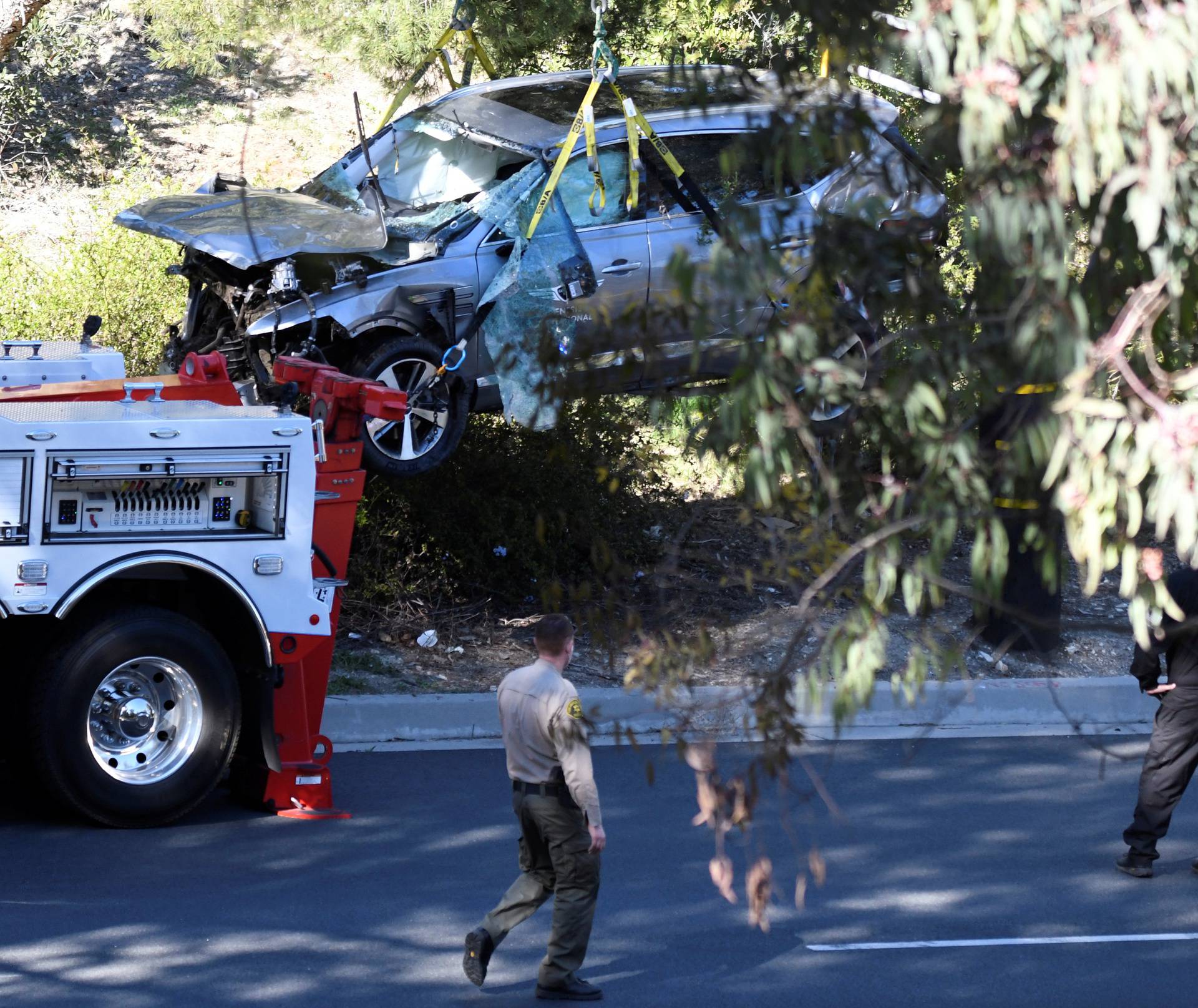 The vehicle of golfer Tiger Woods is lifted by a crane in Los Angeles