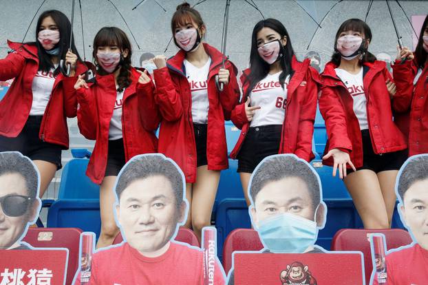 Cheerleaders take group photos with face masks on due to the outbreak of the coronavirus disease (COVID-19) at the first of the professional baseball league game at Taoyuan International baseball stadium in Taoyuan city