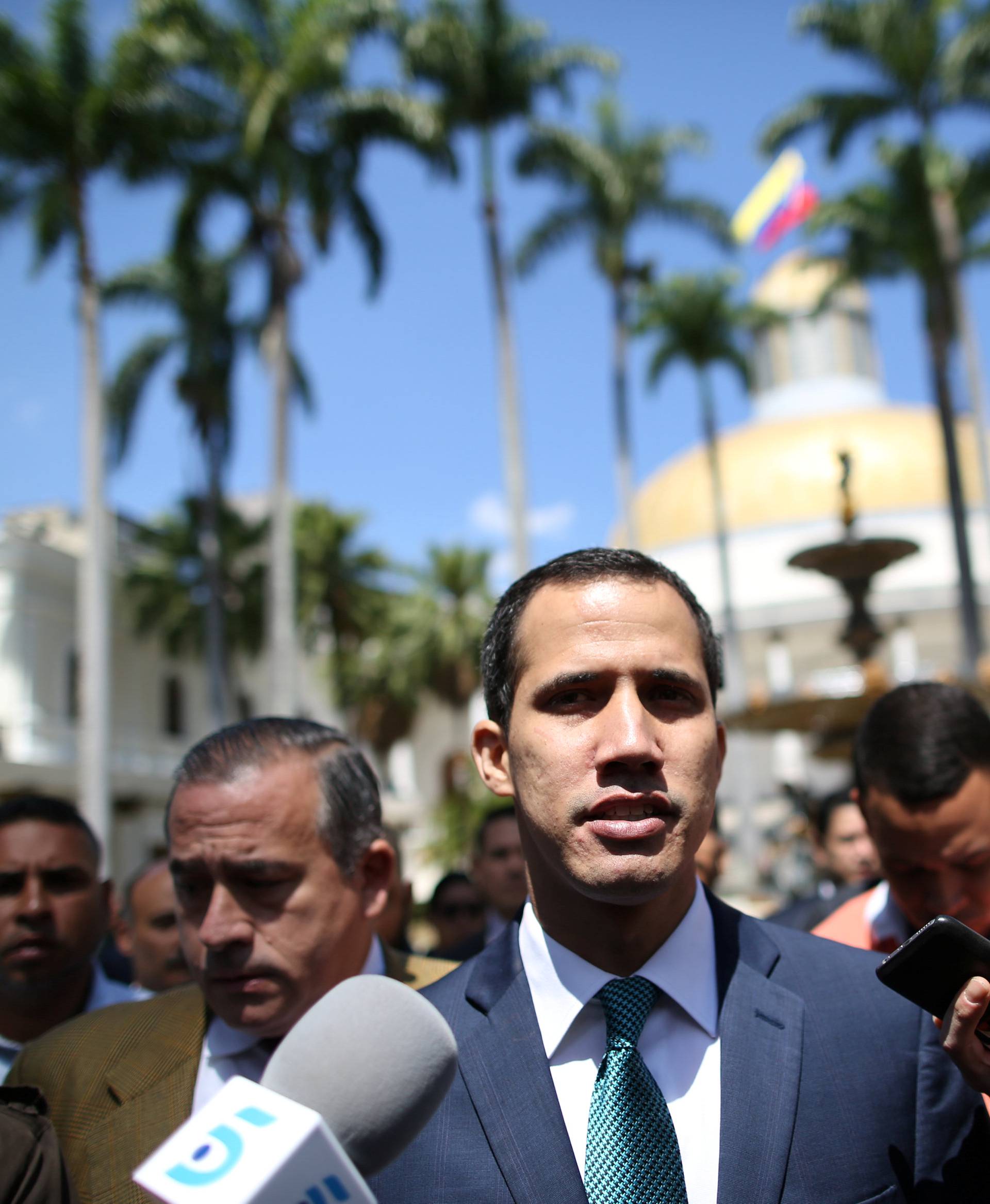 Venezuelan opposition leader Juan Guaido walks as he speaks to journalists before a news conference at the National Assembly in Caracas