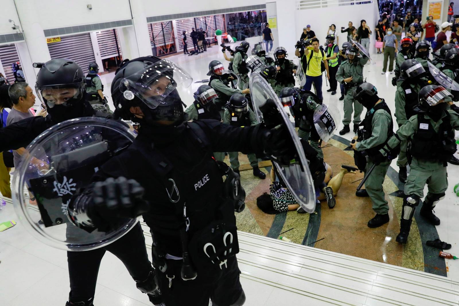 Riot police detain an anti-government protester at a shopping mall in Tai Po, Hong Kong