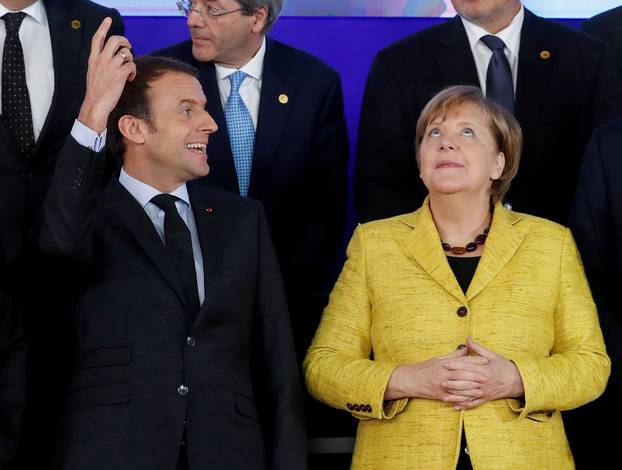 French President Emmanuel Macron and German Chancellor Angela Merkel take part in a group photo on the launching of PESCO