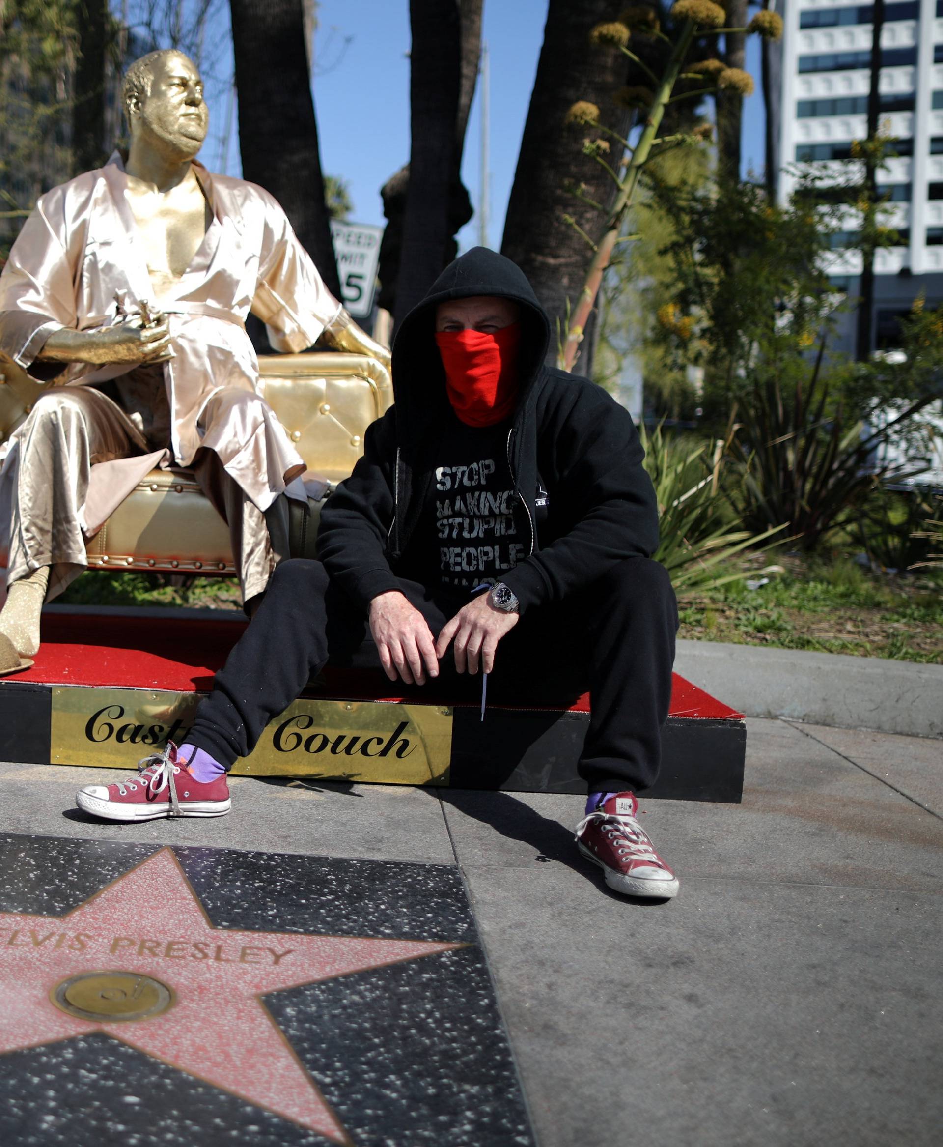 Artist Plastic Jesus sits on his statue of Harvey Weinstein on a casting couch on Hollywood Boulevard near the Dolby Theatre during preparations for the Oscars in Hollywood, Los Angeles
