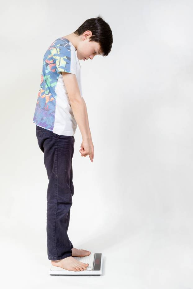 Young boy looking at how much he weighs