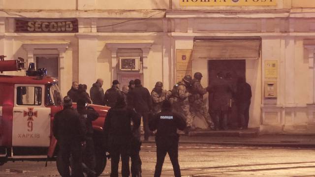 Members of a police special operations unit gather outside a post office, where a man took people hostage, in Kharkiv