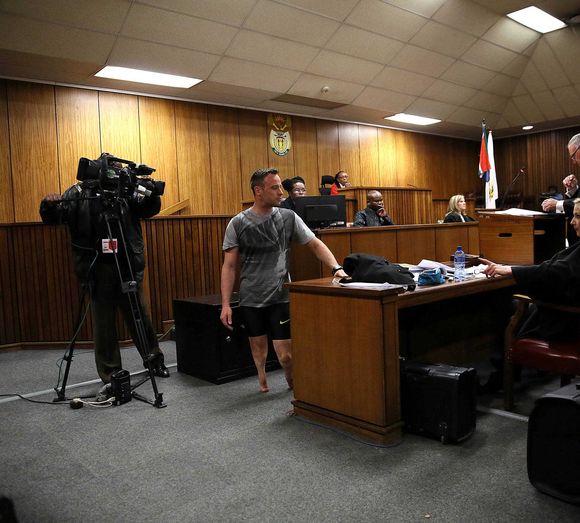 Paralympic gold medalist Oscar Pistorius walks across the courtroom without his prosthetic legs during the third day of his resentencing hearing for the 2013 murder of his girlfriend Reeva Steenkamp