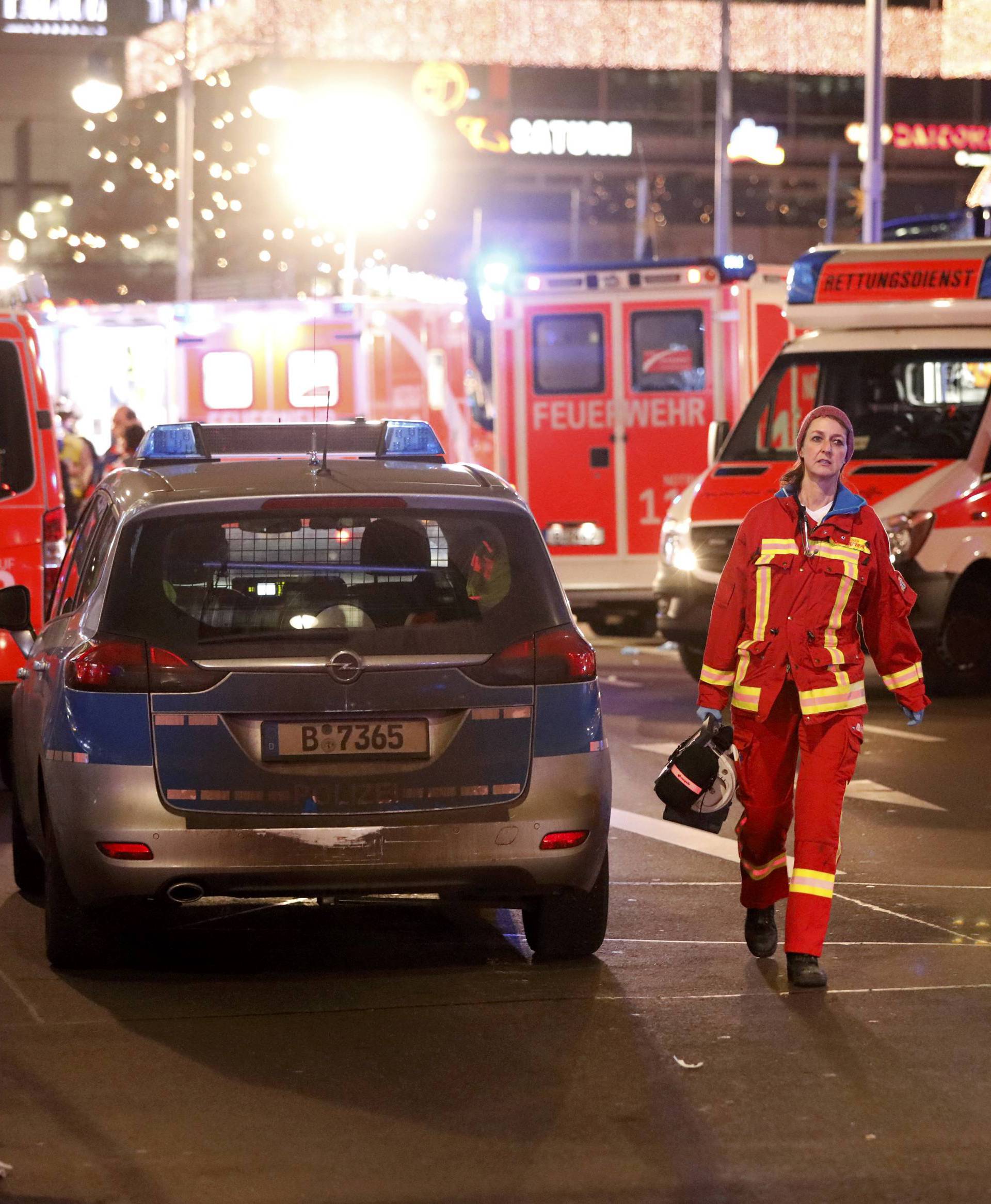 An official walks past ambulances at a Christmas market in Berlin