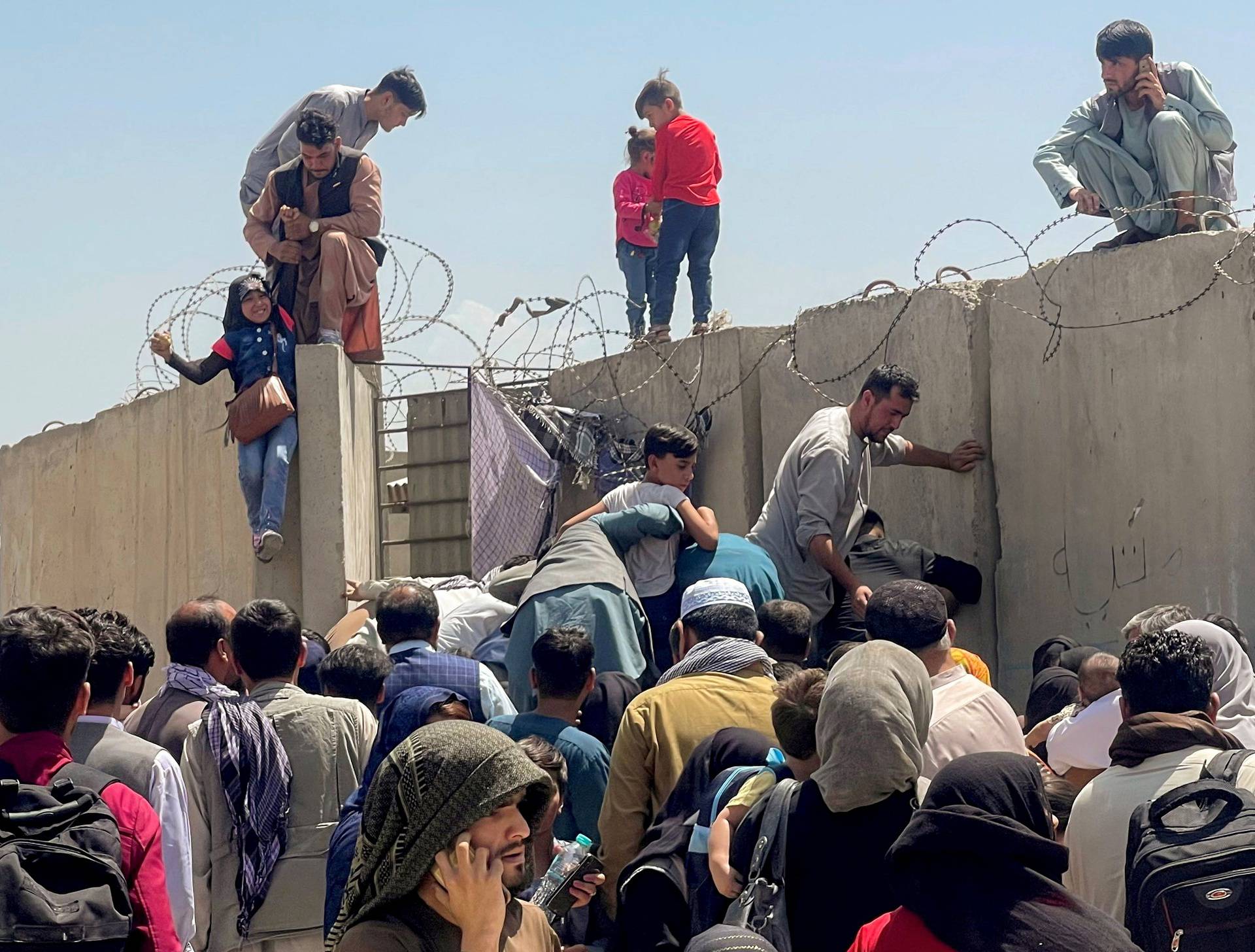 FILE PHOTO: A man pulls a girl to get inside Hamid Karzai International Airport in Kabul