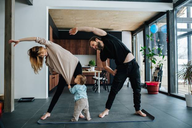 Family,Doing,Yoga.,Mother,And,Father,Doing,Side,Tilts,As