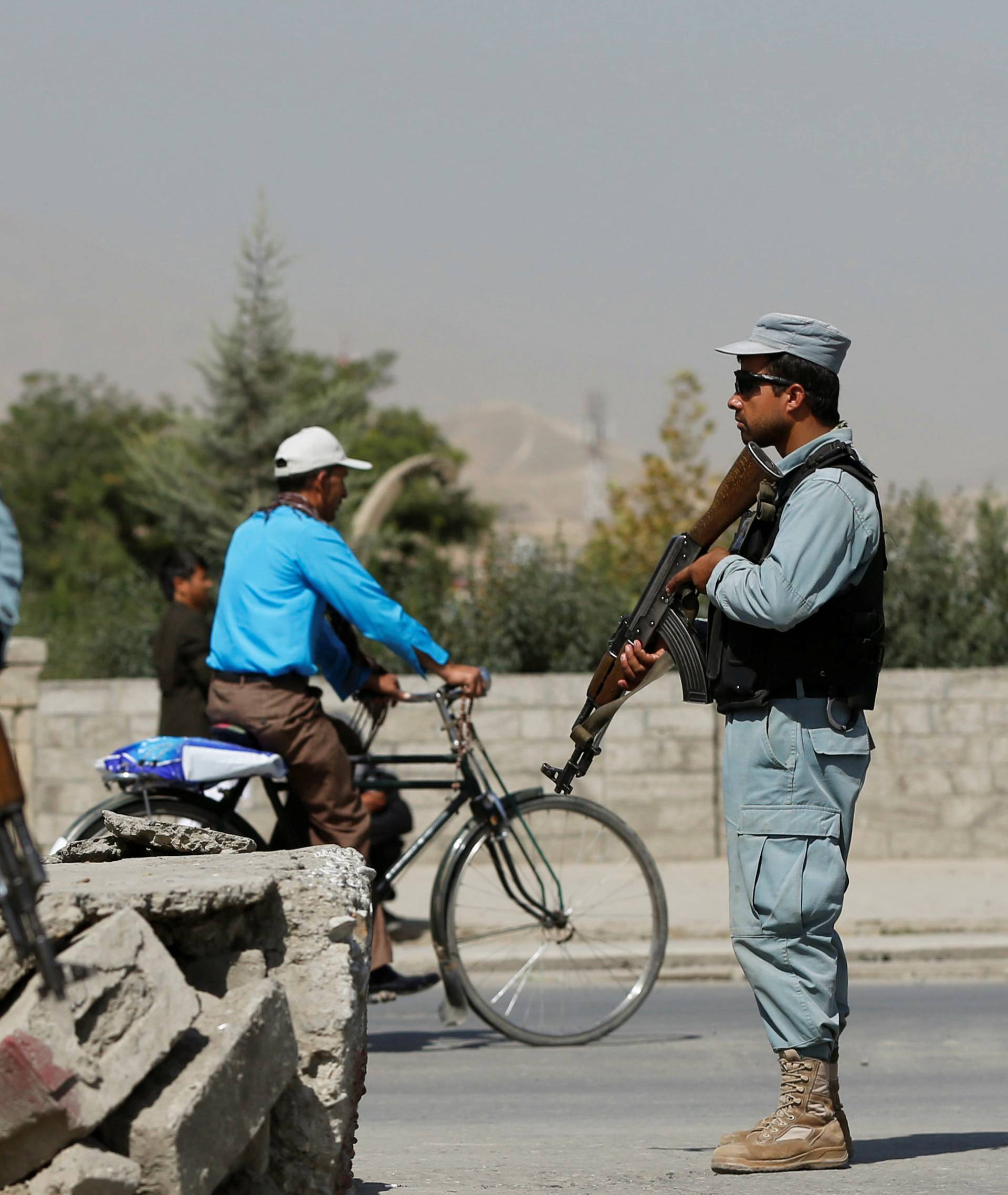 Afghan policemen stand guard at a checkpoint near the site of kidnapping in Kabul, 