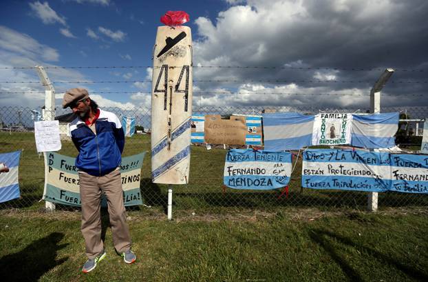 A man stands in front of signs in support of the missing crew members of the ARA San Juan submarine in Mar del Plata