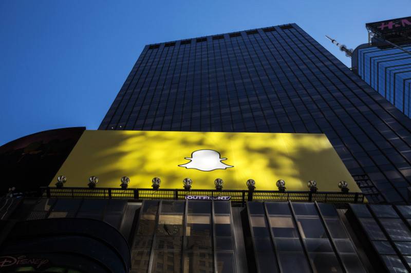 A billboard displays the logo of Snapchat above Times Square in New York