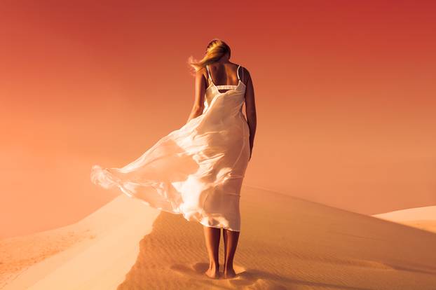 Woman in fluttering dress. Desert and sand dunes. Red sky. Mars.
