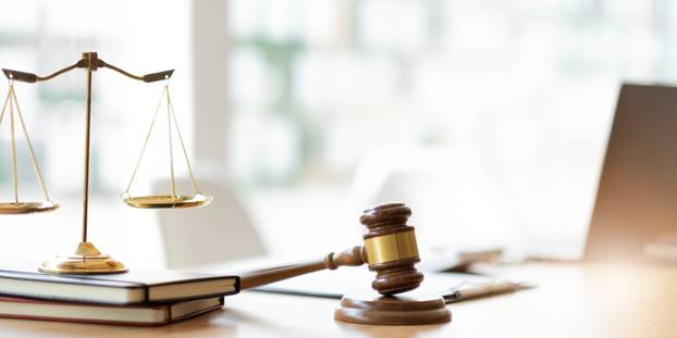 Business and lawyers discussing contract papers with brass scale