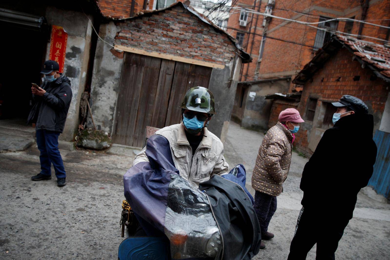 People wear masks in an old neighbourhood in Jiujiang