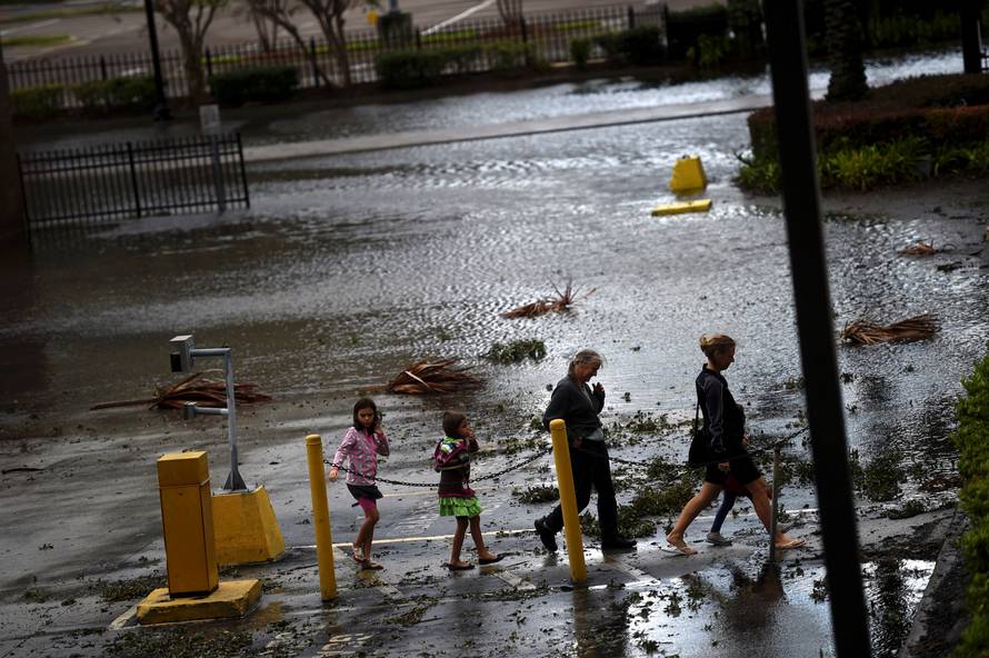 A family walks through floodwaters after Hurricane Irma