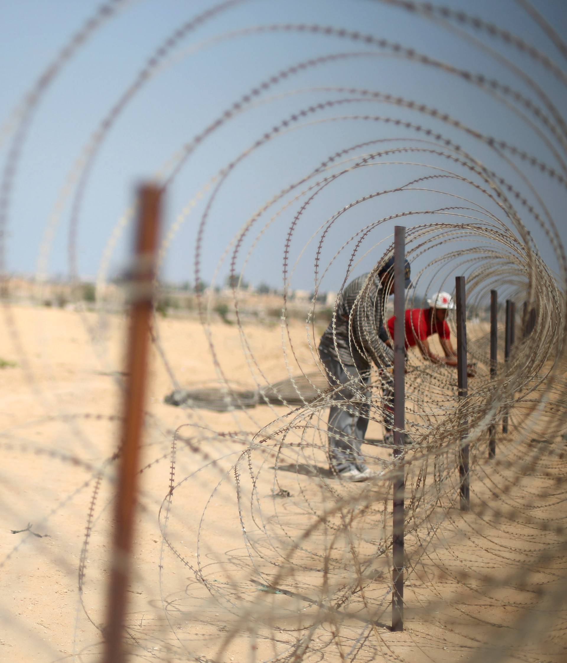 FILE PHOTO: A member of the Palestinian security forces, loyal to Hamas, stands guard as men set up a barbed wire on the border with Egypt, in Rafah in the southern Gaza Strip