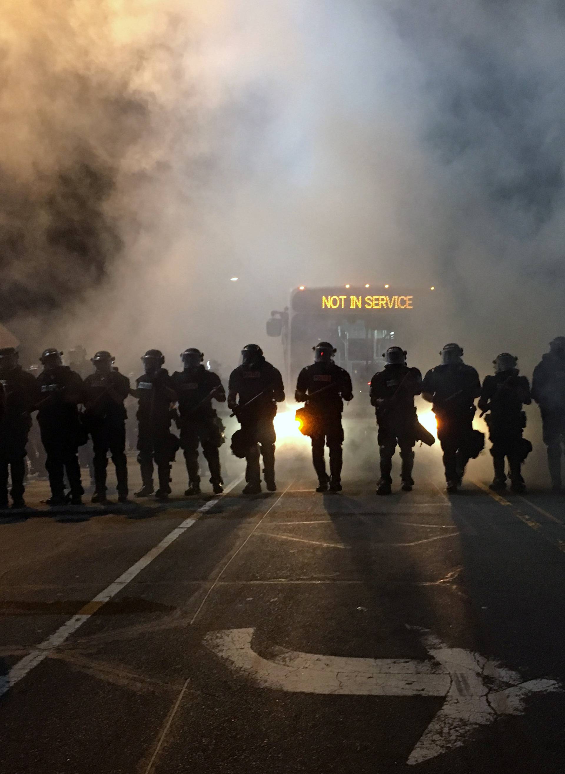 Police officers wearing riot gear block a road during protests  after police fatally shot a man in the parking lot of an apartment complex in Charlotte