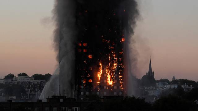 Flames and smoke billow as firefighters deal with a serious fire in the Grenfell Tower apartment block at Latimer Road in West London