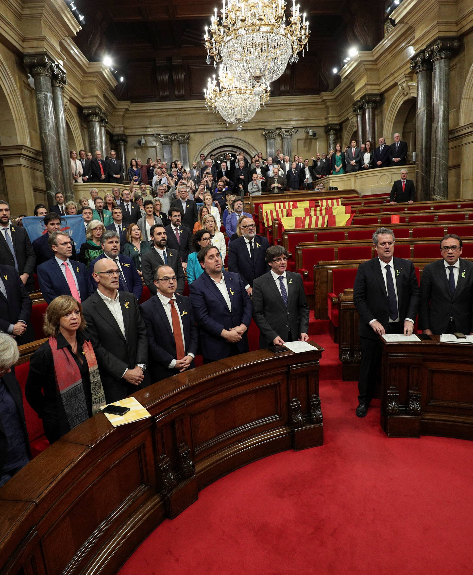 Catalan government and pro independence deputies sing the Catalan anthem after the Catalan regional Parliament declared independence from Spain in Barcelona