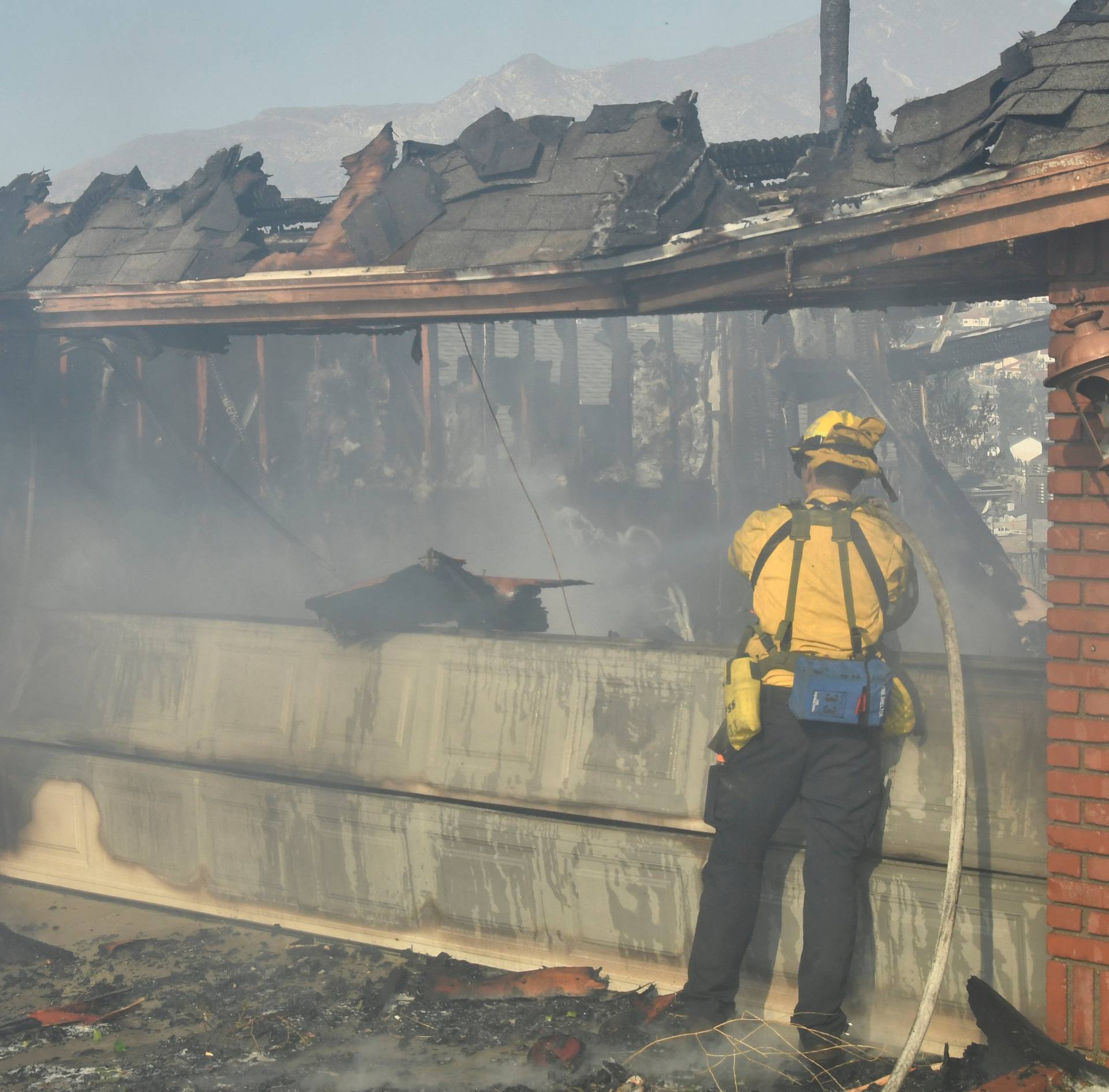 A firefigher responds to one of many home destroyed by an early-morning Creek Fire that broke out in the Kagel Canyon area in the San Fernando Valley north of Los Angeles