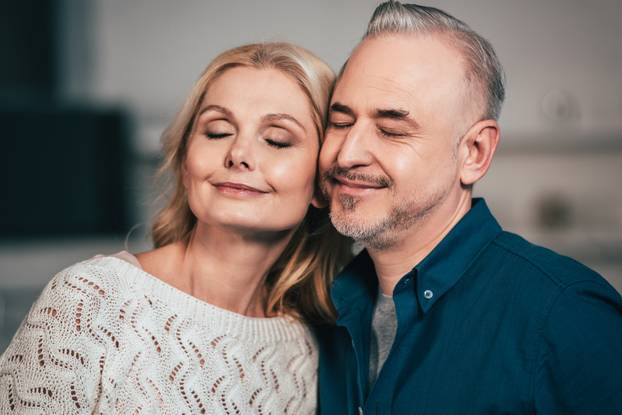 happy wife and husband smiling with closed eyes at home