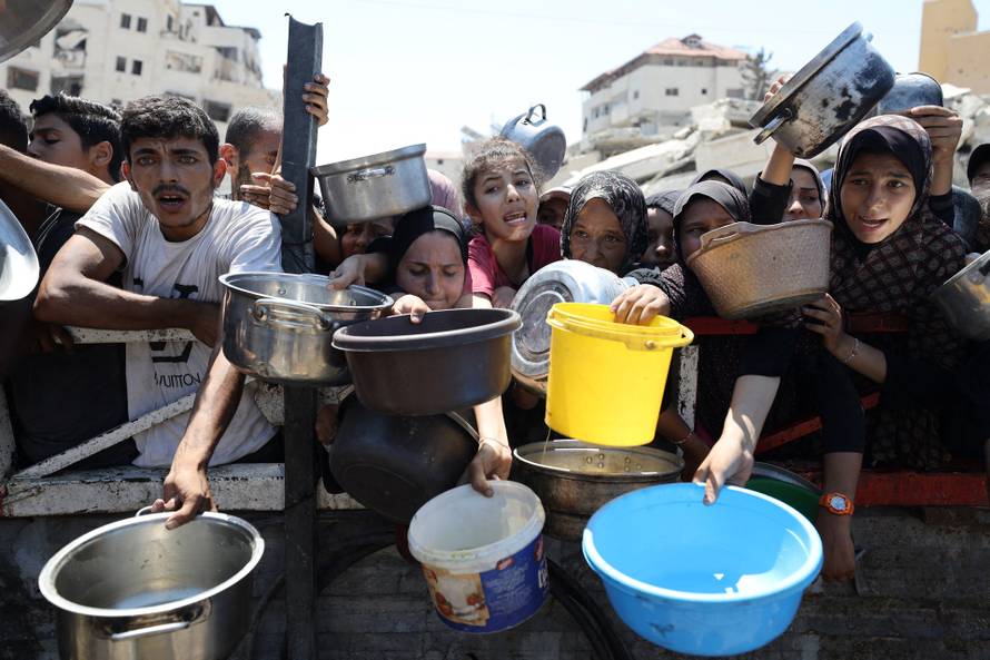 Palestinians receive food from charity kitchen, in Gaza City