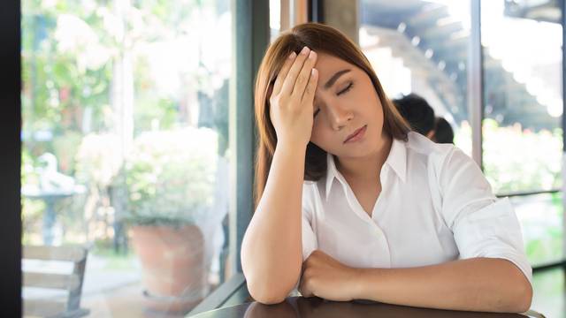 Woman has head ache at coffee shop