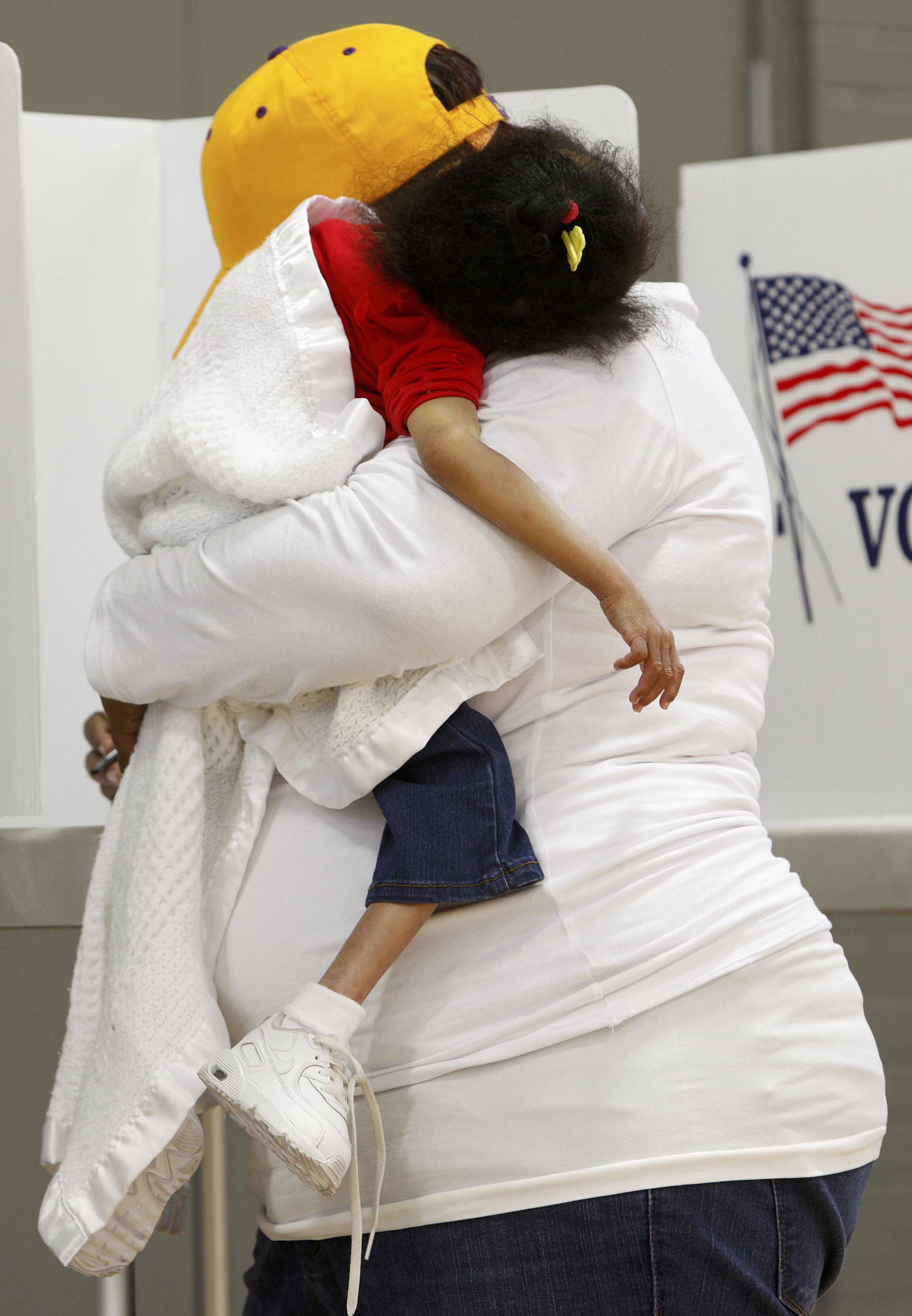 A mother carries her sleeping child while voting during the U.S. general election in Greenville, North Carolina