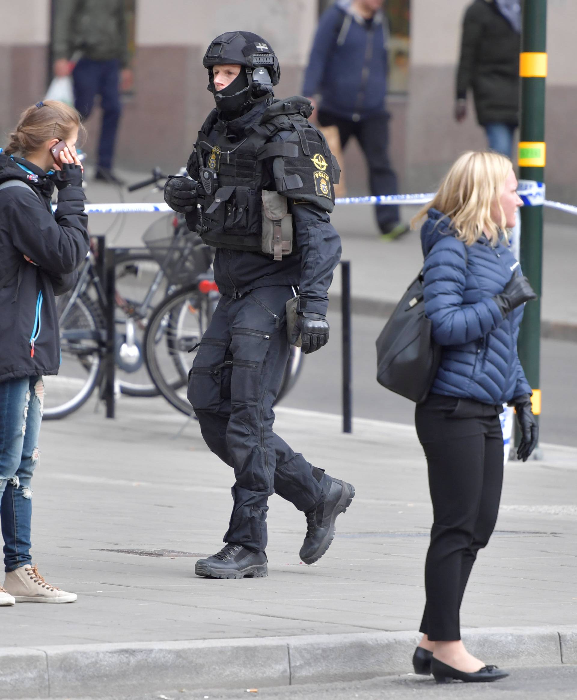 A policeman is seen evacuating Stockholm Central Train Station after people were killed when a truck crashed into department store Ahlens, in central Stockholm