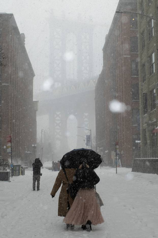 People walk amid a major winter storm spreading across a large swath of the United States, in Brooklyn