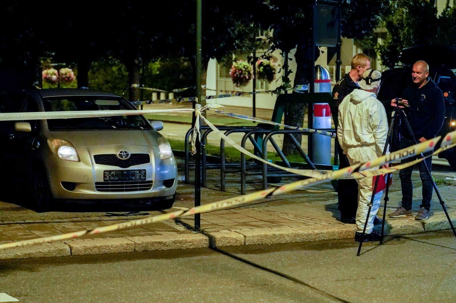 Police tape and police officers are seen near a vehicle after multiple stabbings in Sarpsborg