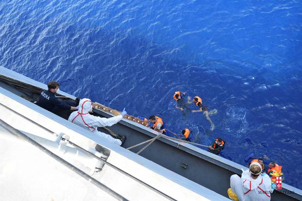 Migrants from a capsized boat are rescued during a rescue operation by Italian navy ships "Bettica" and "Bergamini" off the coast of Libya