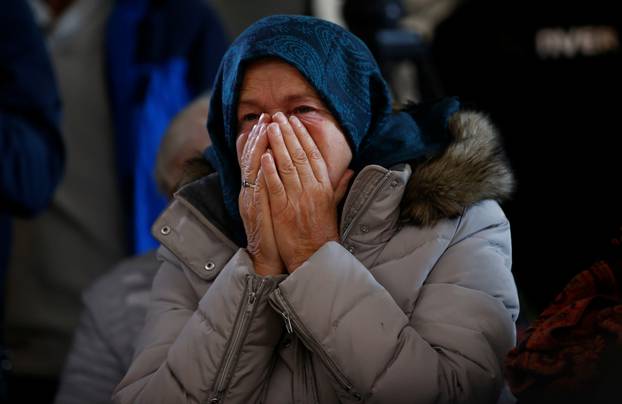 A woman reacts as she watches a television broadcast of the court proceedings of former Bosnian Serb general Ratko Mladic in the Memorial centre Potocari near Srebrenica