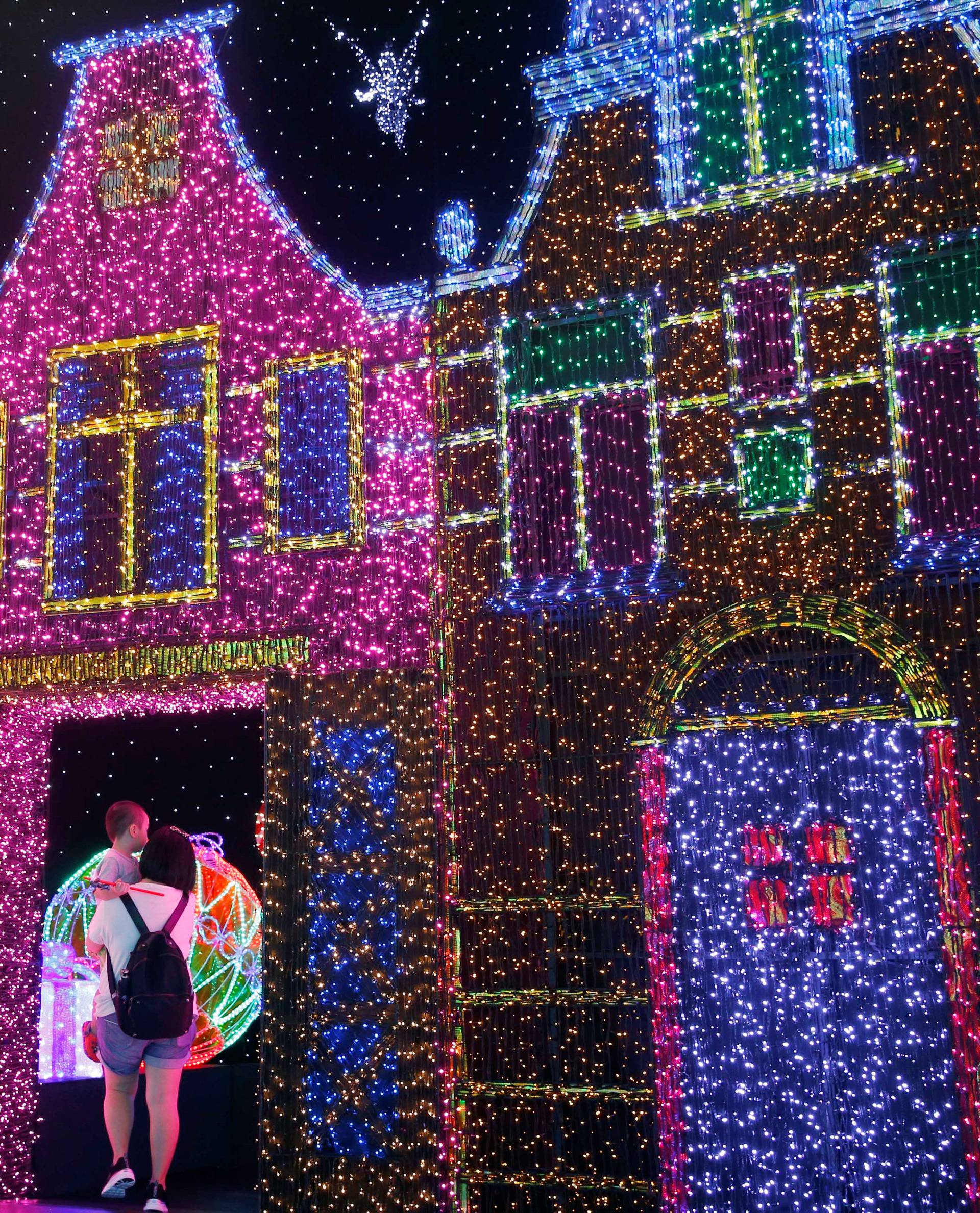People tour a Christmas attraction featuring a display of more than 800,000 light bulbs in Universal Studios Singapore